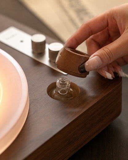 Lifting the walnut cap to reveal the essential-oil well