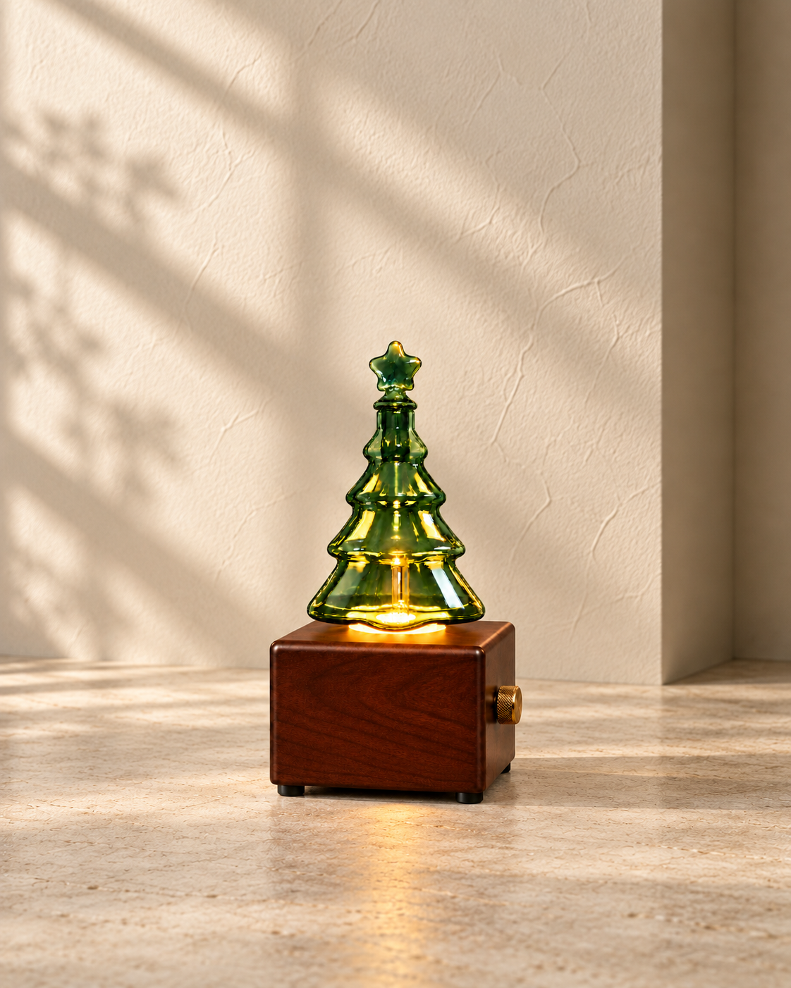 Wood-finish Christmas tree diffuser with illuminated green glass, amber light and a single brass control on the right side.