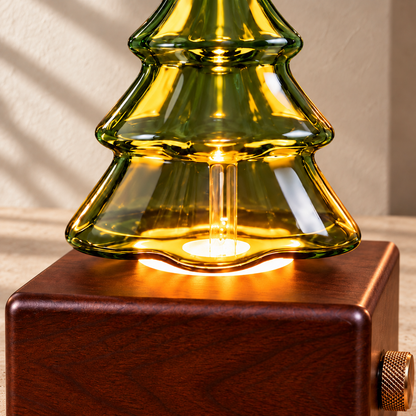 Close-up of clean green Christmas tree glass, the warm light socket and a wood-finish diffuser base.