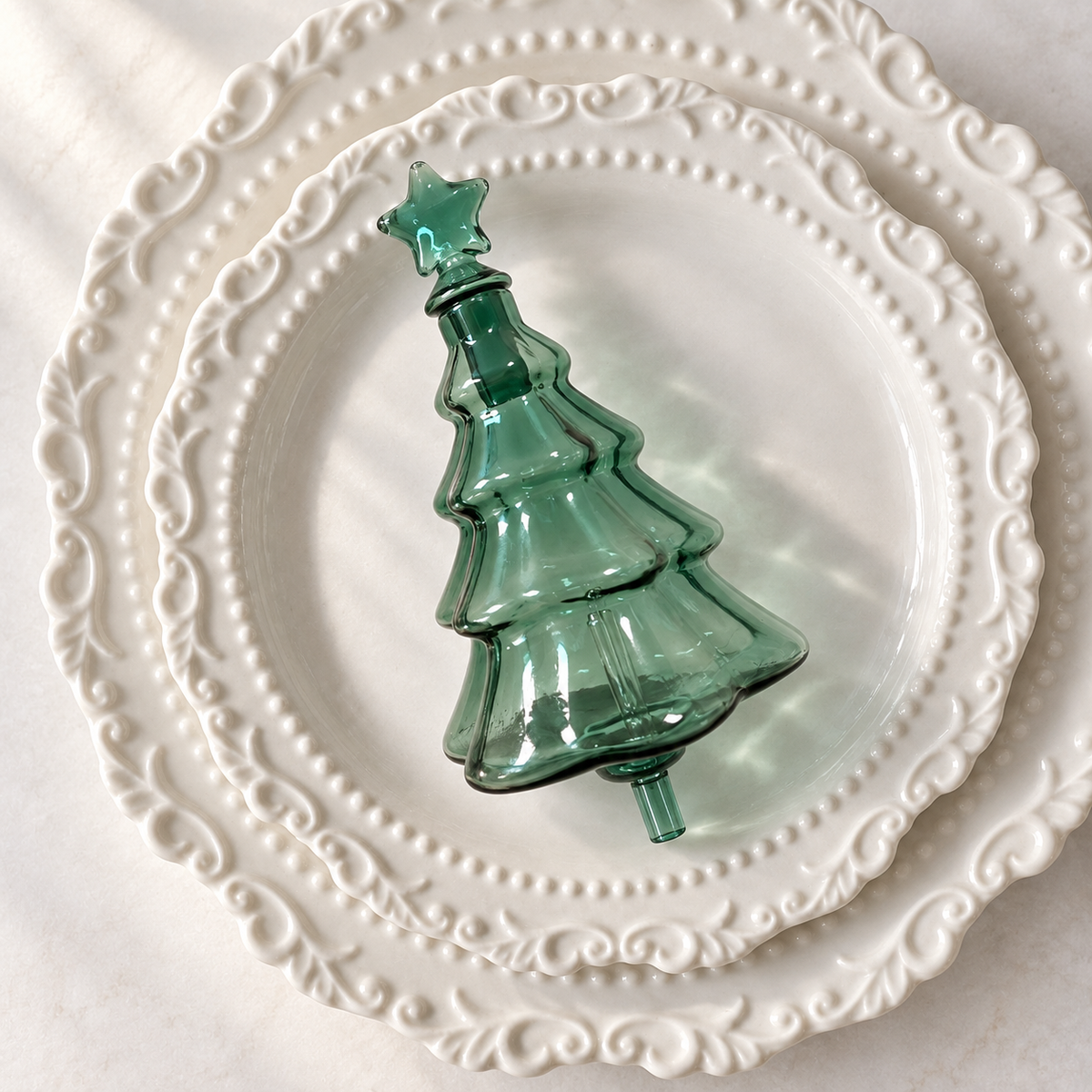 Green Christmas Tree Aroma Glass Bulb with star cap on a white porcelain plate