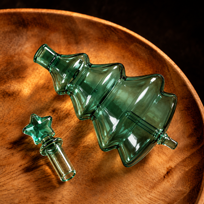 Green Christmas Tree Aroma Glass Bulb with open cylindrical neck and removable star cap on a wooden tray