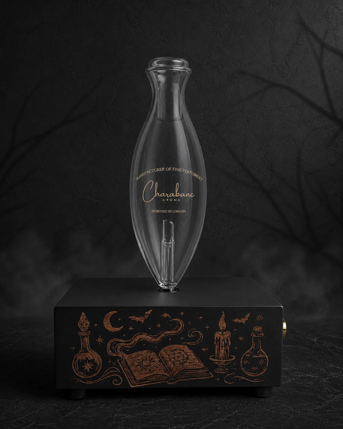 The Apothecary copper-engraved black MINI diffuser with Classic Charabanc Aroma glass bottle in a charcoal Halloween setting