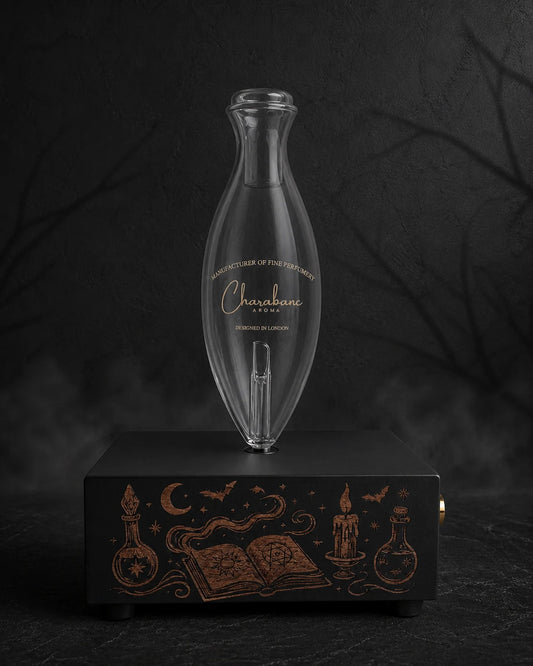 The Apothecary copper-engraved black MINI diffuser with Classic Charabanc Aroma glass bottle in a charcoal Halloween setting