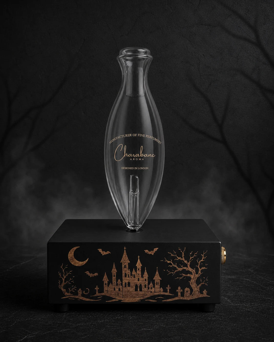 The Haunted Castle copper-engraved black MINI diffuser with Classic Charabanc Aroma glass bottle in a charcoal Halloween setting