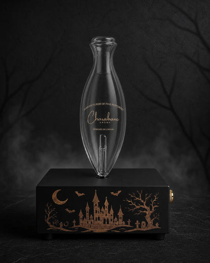 The Haunted Castle copper-engraved black MINI diffuser with Classic Charabanc Aroma glass bottle in a charcoal Halloween setting