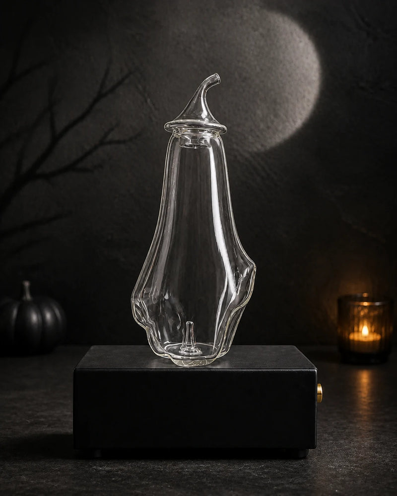Blank hand-blown ghost bottle on the black rechargeable Charabanc MINI diffuser base in a moonlit Halloween setting